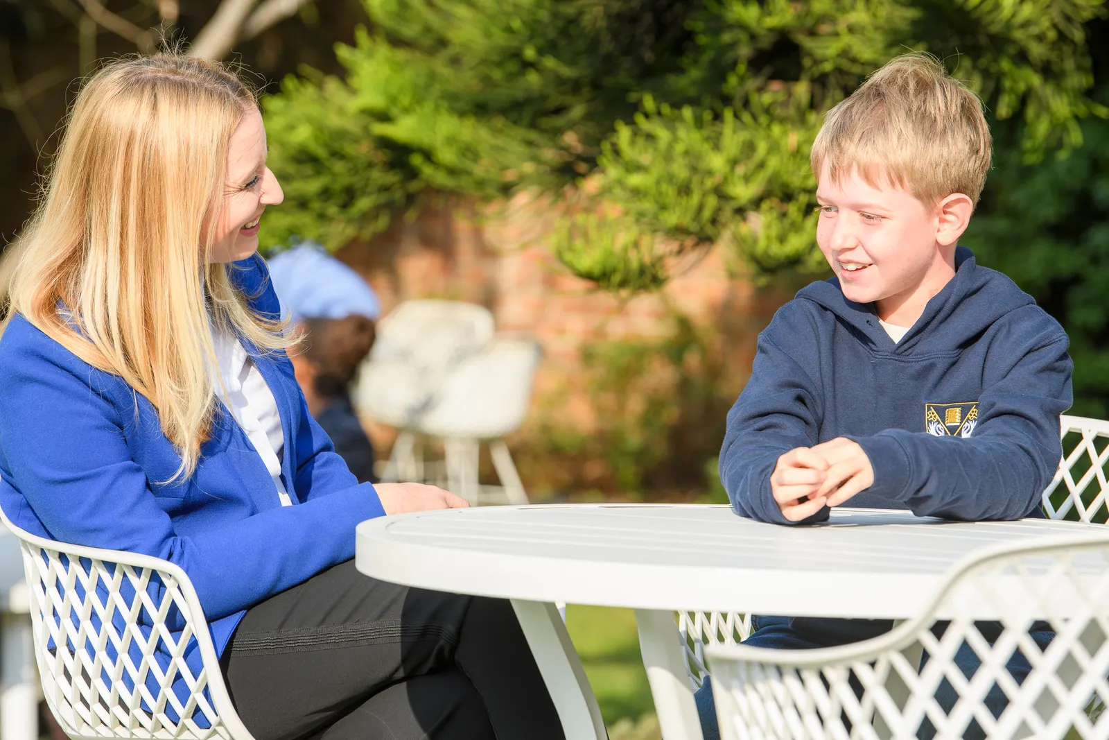 A Genius Education Leader and student sharing a warm conversation outdoors