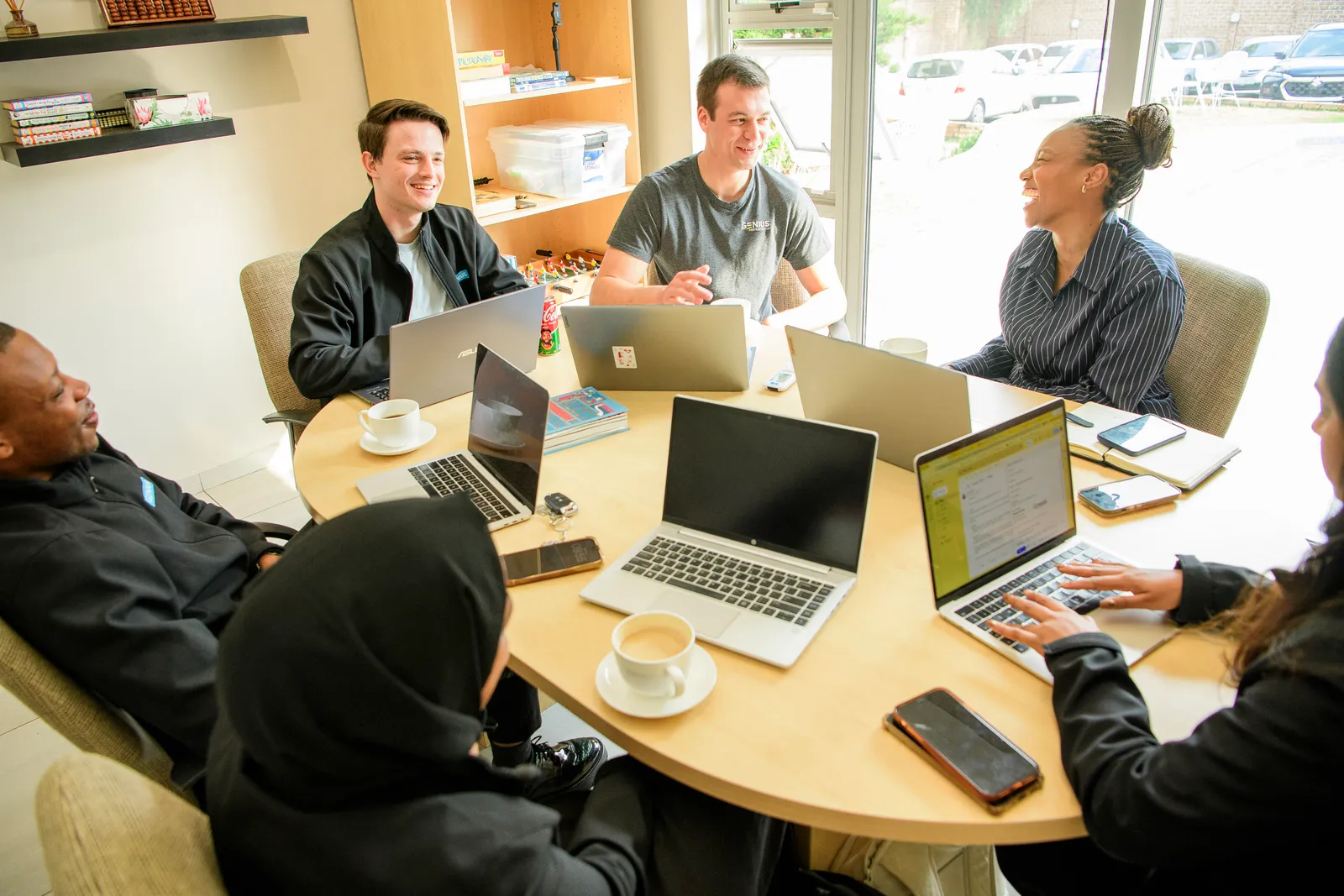 The Genius team sharing a candid moment around a working table