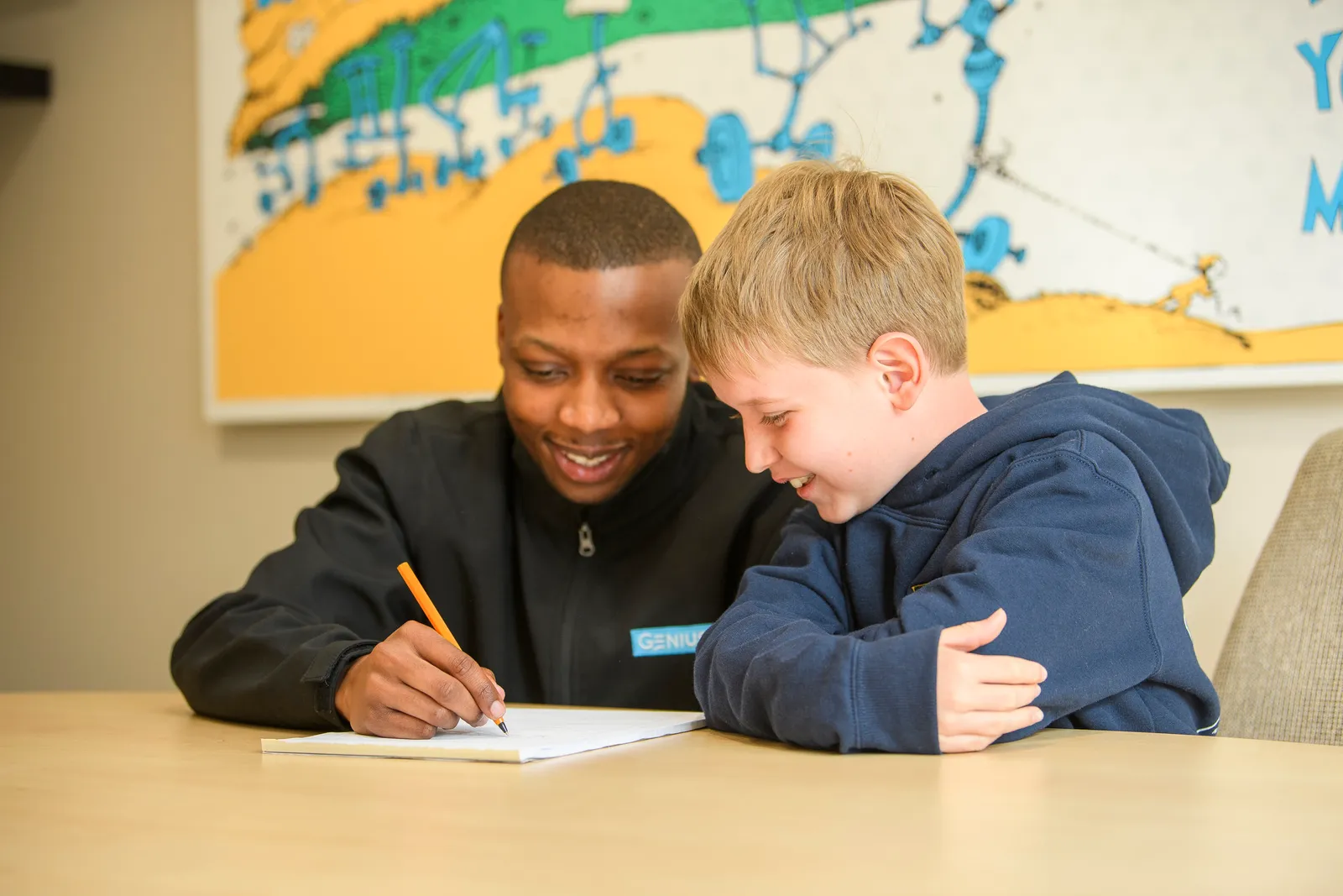 A Genius tutor watching a student work independently during a lesson