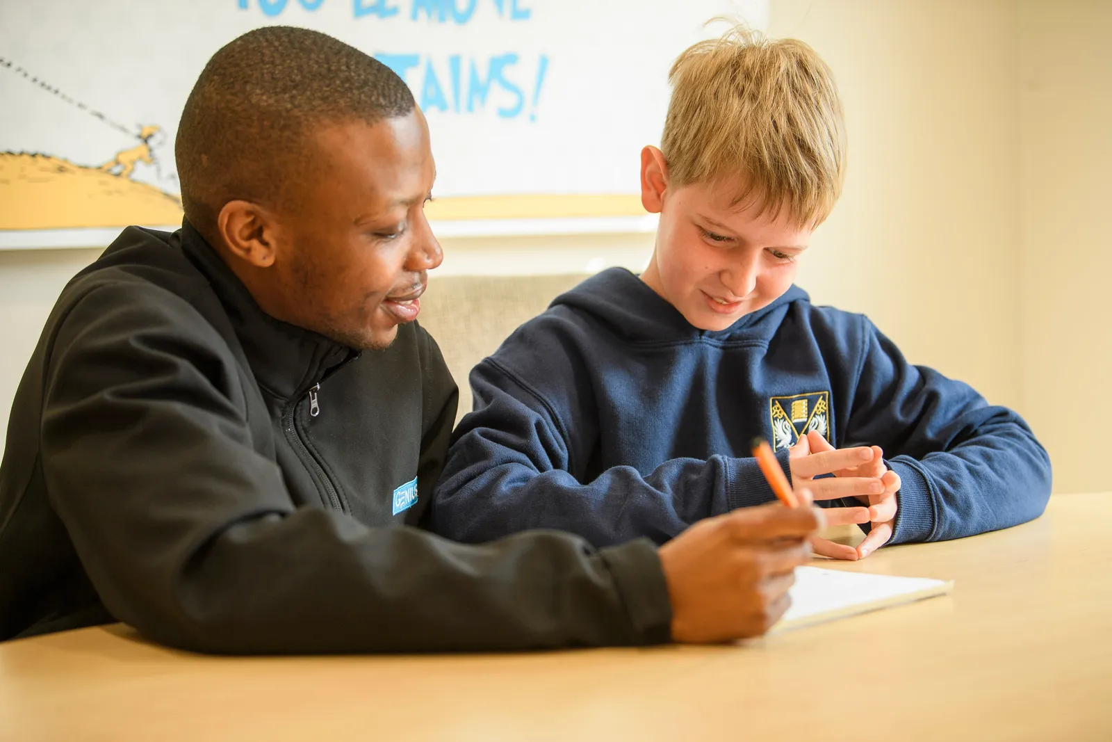 A Genius tutor encouraging a young learner during a one-to-one lesson