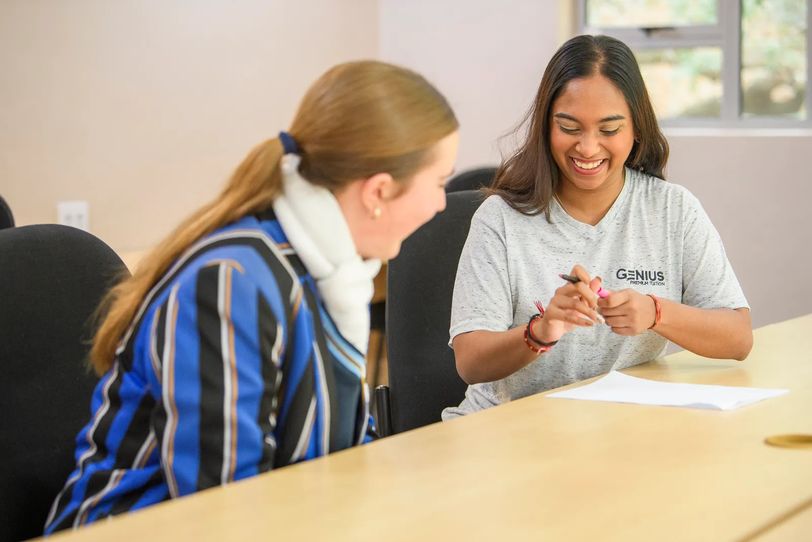 A Genius tutor and student sharing a light moment during a lesson